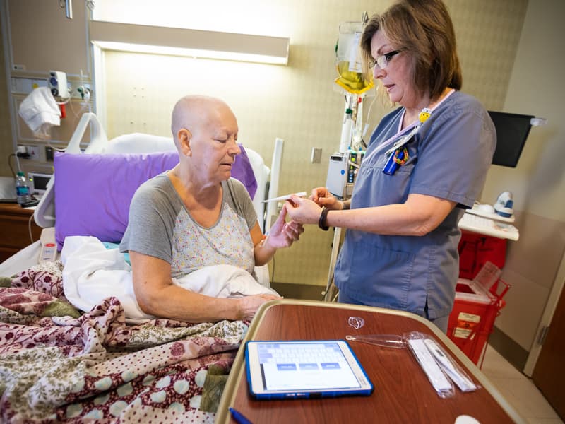 Shirley Crnkovic reviews the equipment she'll take home with Bone Marrow Transplant outpatient nurse Rebecca Smith.