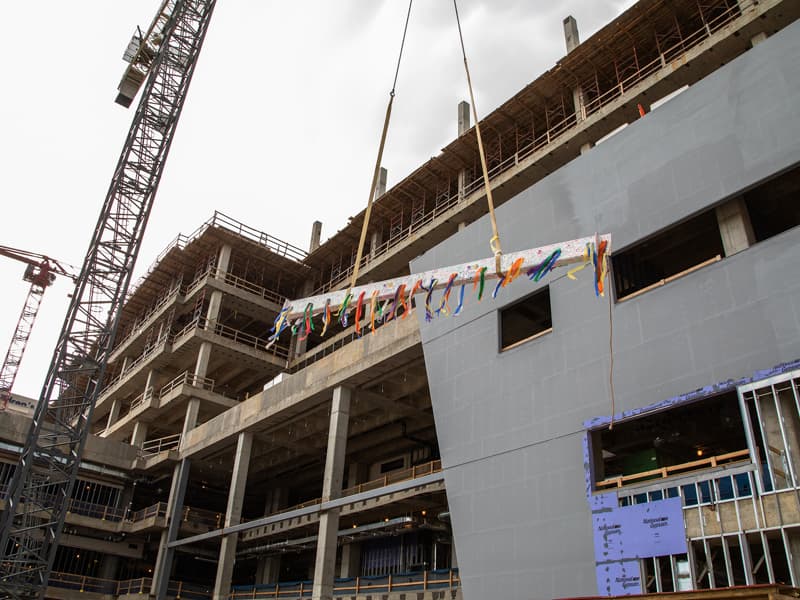 The ceremonial construction beam, decked with streamers, rises toward the top of UMMC's seven-story pediatric expansion.