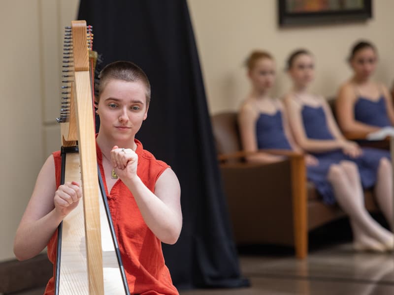 Harpist/vocalist Laura Pitts performs one of three musical selections as dancers from Ballet Mississippi wait in the wings.