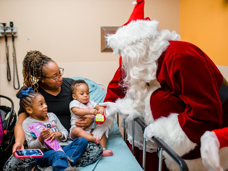 Santa gives Zaharia Primer of Jackson and her sister, Amelia, leftt, toys during his annual stop at Children's of Mississippi.