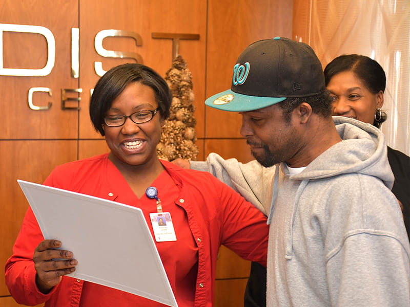As part of Michael Jordan’s festive send-off, Methodist Specialty Care Center Activities Director Courtney Jones presented him with a card signed by staff and other residents. Photo by Carey Miller/Methodist Rehabilitation Center