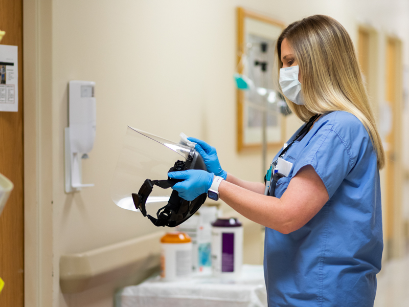 Labor and Delivery registered nurse Melissa Taylor cleans a face shield.