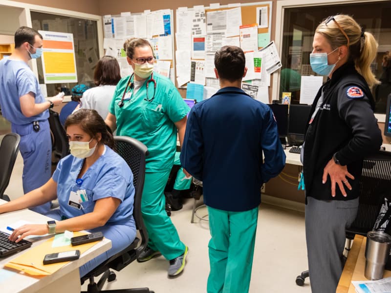 Dr. Risa Moriarity, right, executive vice chair of emergency medicine, and Adult Emergency Department staff discuss the afternoon's patients.
