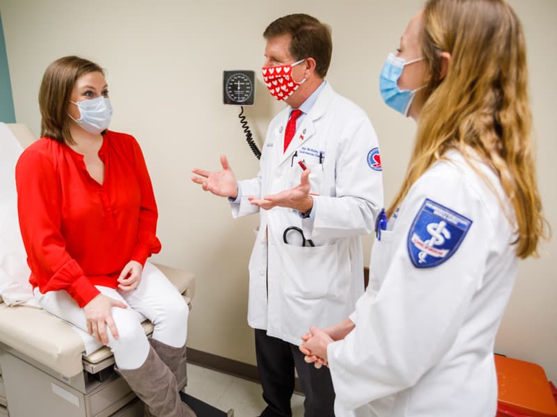 Adult congenital heart failure patient Kelly Gordon of Brandon, left, listens as her cardiologist, Dr. Michael McMullan, discusses her care during a recent check-up. Observing is fourth-year School of Medicine student Ruth Reese.