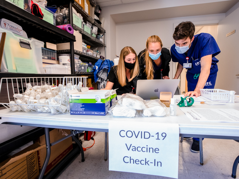 School of Medicine students Sydney Hays, left, Lauren Pole and Michael Hohl check in patients with appointments to receive the COVID-19 vaccine Saturday at the Jackson Free Clinic.
