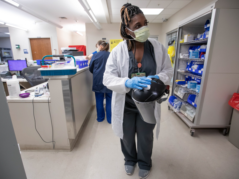 Phlebotomist Deanna Baber sanitizes her PPE while working her shift in the Med-Surg area of the UMMC Emergency Department.