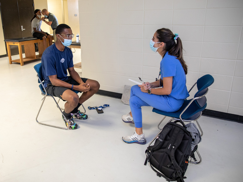 Family Medicine resident Dr. Erika Wachs, right, chats with JSU baseball player Hasan Standifer of Harbor City, California, before he undergoes a physical exam.
