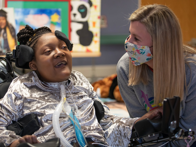 Children's of Mississippi patient DeAsia Scott shares a laugh with palliative and complex care team member RN Shannon Brown.