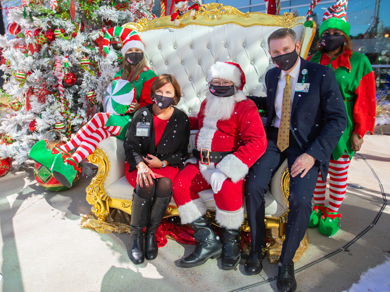 Volunteer elves Erica Bradshaw, left, and Gail Willridge flank Santa Claus with Dr. Mary Taylor, Suzan B. Thames Chair and professor of pediatrics, and Children's of Mississippi CEO Guy Giesecke during BankPlus Presents Winter Wonderland.