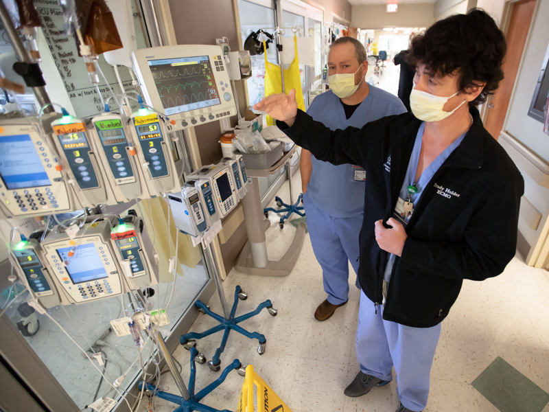 Brady Holder, right, interim director of respiratory care, ECMO and associated clinical programs, and Brinson discuss a ventilator monitor in the MICU.