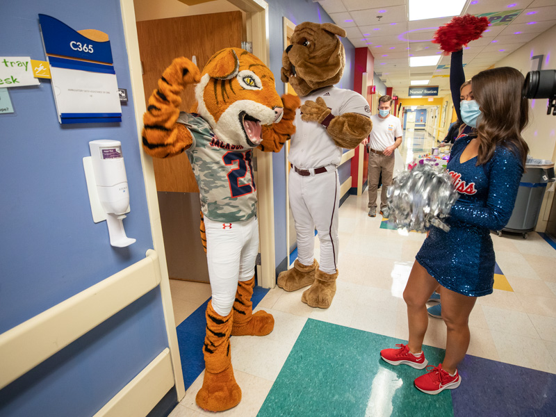 Sonny Thee Tiger and Bully pose outside of Children's of Mississippi patient rooms as Liston, left, and Granberry cheer on. Jay Ferchaud/ UMMC Communications