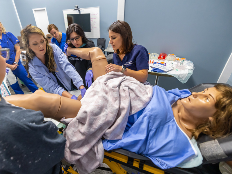 From left, Lackey Memorial registered nurses Hayden Neal, Lackey Memorial nurse practitioner Kacey Jones, Lackey Memorial registered nurse Kristen Robinson and UMMC's Dr. Tara Lewis with UMMC practice delivering a baby. Melanie Thortis/ UMMC Communications 