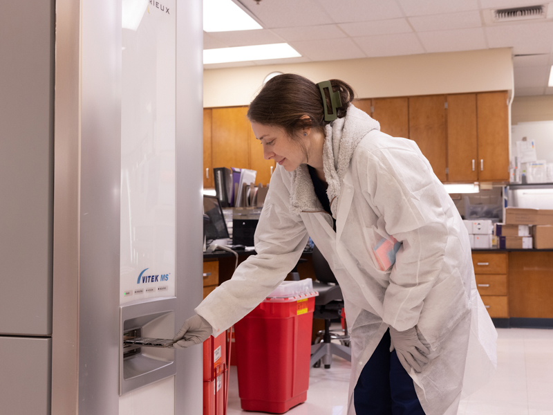 Kayla Miller, a registered medical technologist in UMMC's micro lab, uses sophisticated equipment to determine whether cultures contain microorganisms that can cause a wide range of infections.