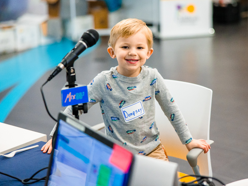Children's of Mississippi patient Dempsey Donahoo smiles at the Mix 98.7 radio booth during the 2022 Mississippi Miracles Radiothon.
