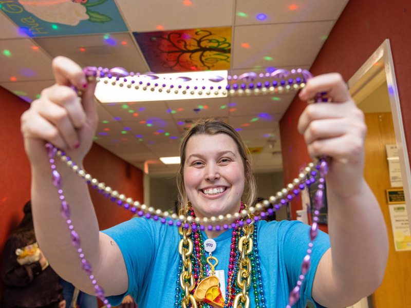 Allyson Holliman holds up Mardi Gras beads during a Friends of Children's Hospital parade Tuesday. Jay Ferchaud/ UMMC Communications 