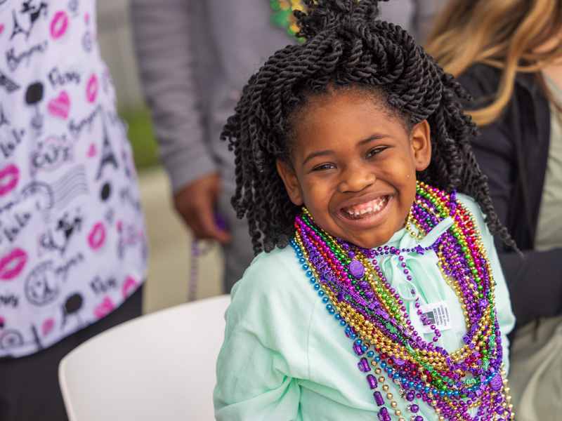 Children's of Mississippi patient Ayanna Adams of Jackson smiles after gathering Mardi Gras beads during the Mississippi Department of Public Safety parade Tuesday. Melanie Thortis/ UMMC Communications 