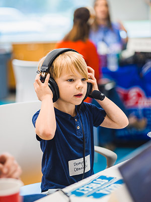 Children's of Mississippi patient Dempsey Donahoo of Madison puts on headphones for an interview during the Mississippi Miracles Radiothon.