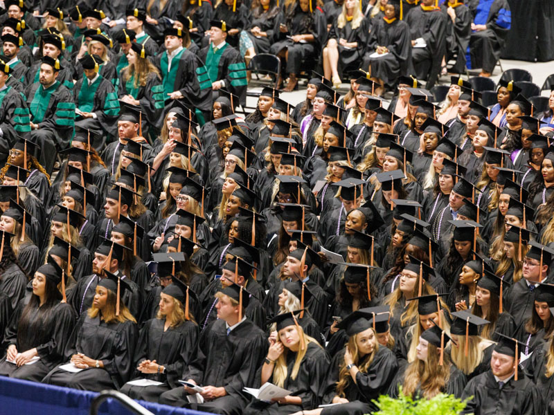Members of the Class of 2023 listen to speakers during commencement. Joe Ellis/ UMMC Communications 