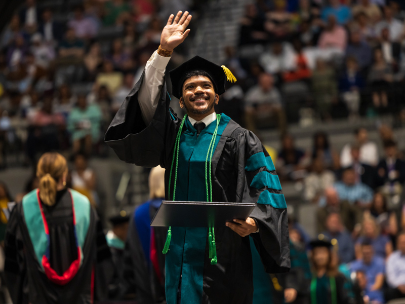 Jeffery Hampton waves to the crowd after receiving a doctor of physical therapy degree from the School of Health Related Professions. Melanie Thortis/ UMMC Communications 