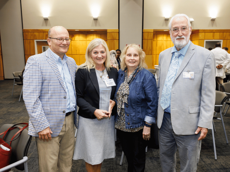 Distinguished alumna Dr. Babbette LaMarca, second from left, stands beside her husband, Darren LaMarca, Dr. Barbara Alexander, who nominated her for the award, and Dr. Larry McDaniel, professor of cell and molecular biology. Joe Ellis/ UMMC Photography 