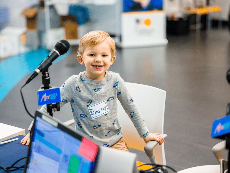 Children's of Mississippi patient Dempsey Donahoo smiles at the Mix 98.7 radio booth during the 2022 Mississippi Miracles Radiothon.