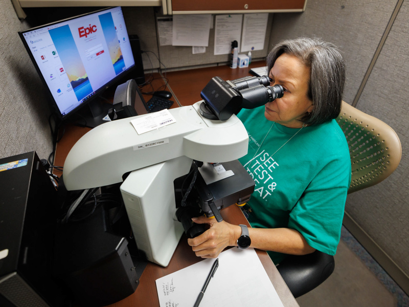 Cytotechnologist Mirna Vargas views patient specimens during See, Test, and Treat.