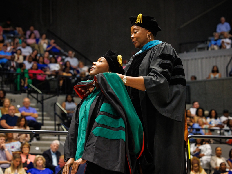 Graduate Felica Gordon is hooded by her mother, Dr. Rita Gordon, assistant professor of Nursing Jay Ferchaud/ UMMC Communications 