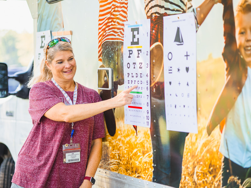 Dr. Lisa Haynie, professor of nursing, points to letters on a chart during a vision screening at the Mississippi Children's Museum.