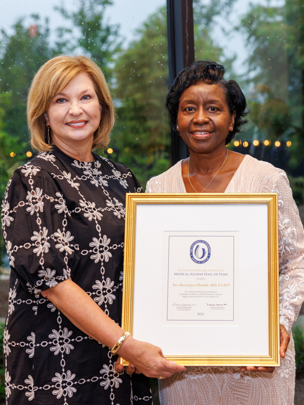 Dr. Joyce Olutade, right, accepts the Medical Hall of Fame award from Dr. LouAnn Woodward.