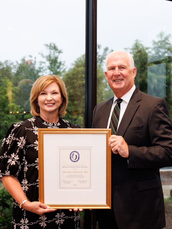 Dr. Alexander Haick Jr. accepts the Medical Hall of Fame honor from Dr. LouAnn Woodward.