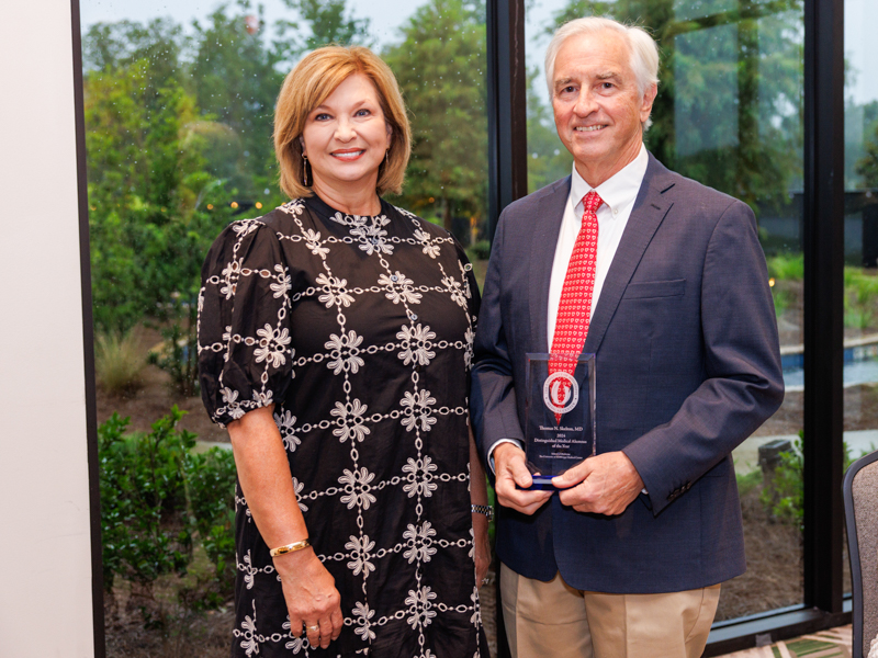 Dr. Thomas Skelton, the 2024 Distinguished Medical Alumnus of the Year, receives his award from Dr. LouAnn Woodward.