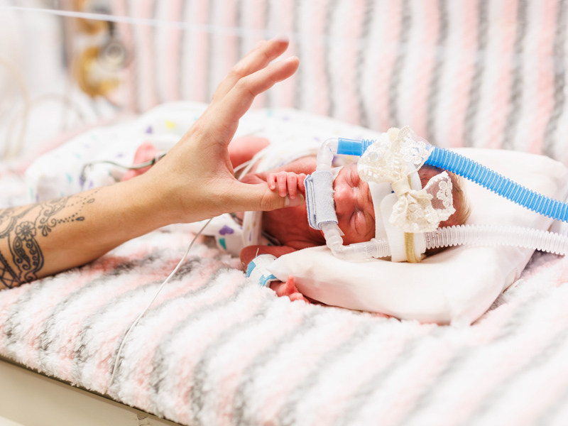 Saylor Kate Meyers holds mother Ashley's thumb.