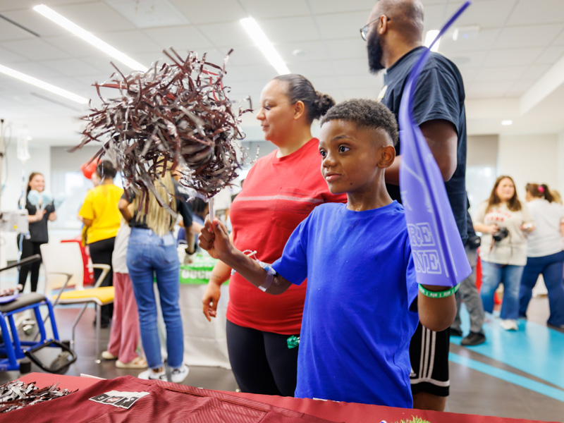 Children's of Mississippi patient Abraham Knox of Columbia shows his team spirit during a Friends of Children's Hospital Tailgate Party.