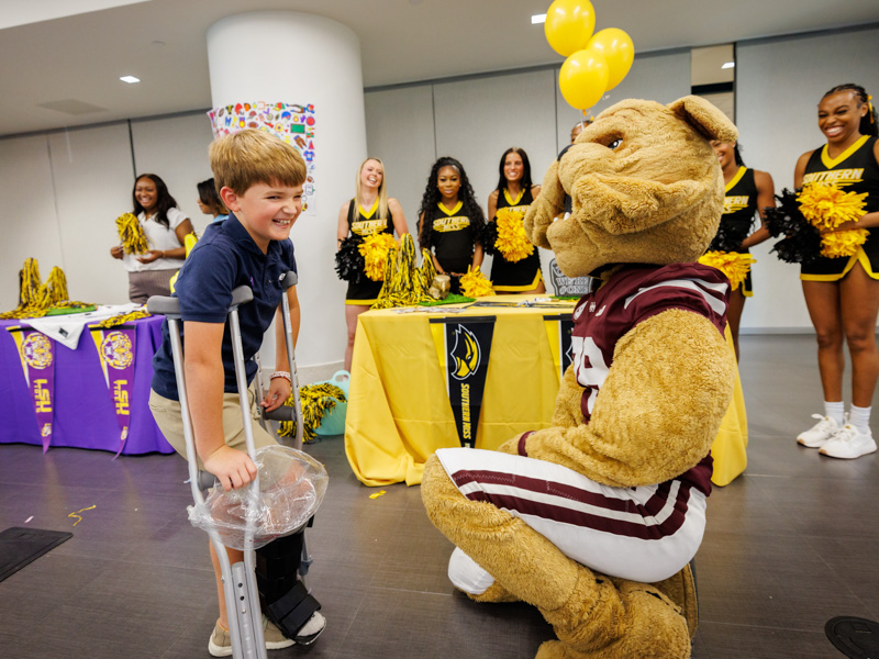 Drake Duncan, 9, of Madison meets Bully, mascot of the Mississippi State University Bulldogs, during a Friends of Children's Hospital Tailgate Party.