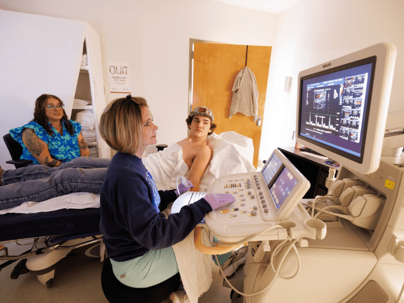 Sherry Reid, cardiology sonographer, scans Tripp Pender's arm in ultrasound during a follow-up appointment.