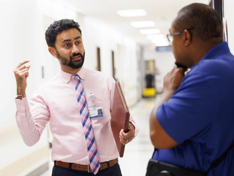 Parikh talks with housekeeping contract worker Earl Thomas about discharge procedures during an informal meeting on 3 North.