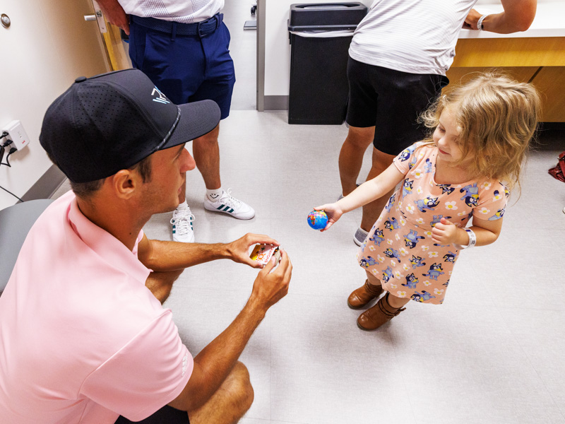 Children's of Mississippi patient Addison Massey of Vicksburg shows her ball to professional golfer Hunter Logan.