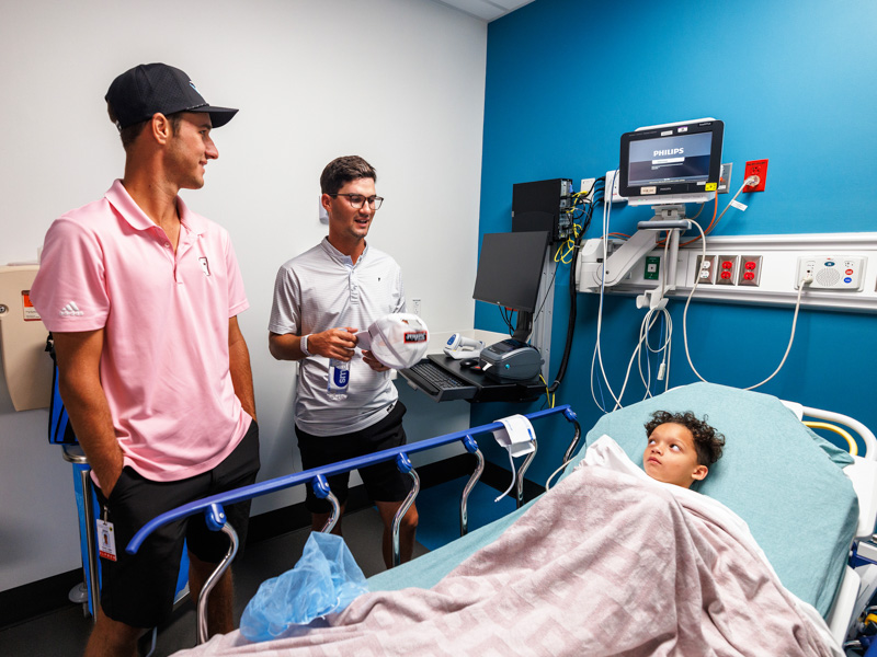 Sanderson Farms Championship golfers Hunter Logan, left, and Philip Knowles talk with Children's of Mississippi patient Kylan Turner of Meridian.