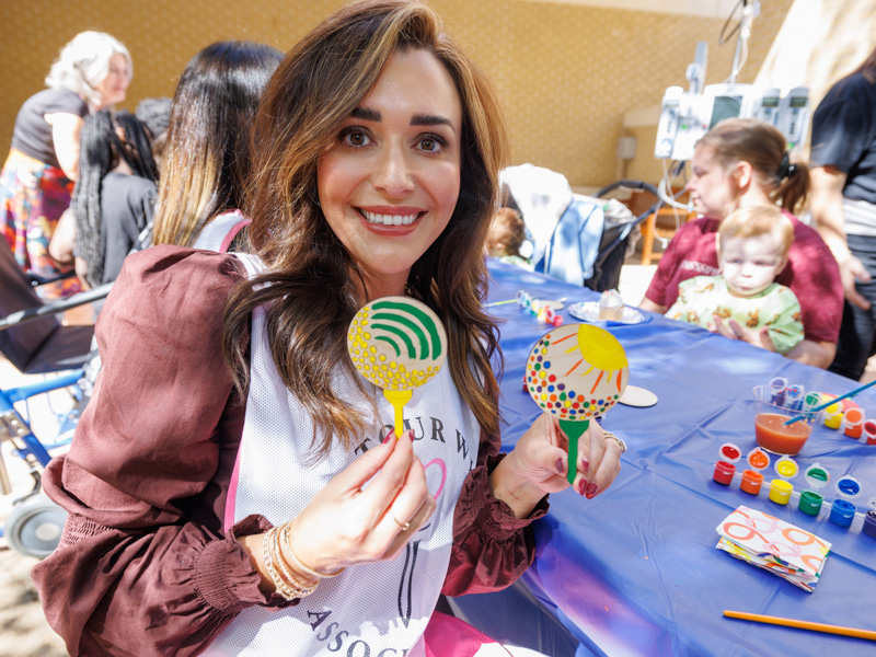 Chloe List, wife of 2023 Sanderson Farms Championship winner Luke List, shows painting projects from a morning of fun with Children's of Mississippi patients.