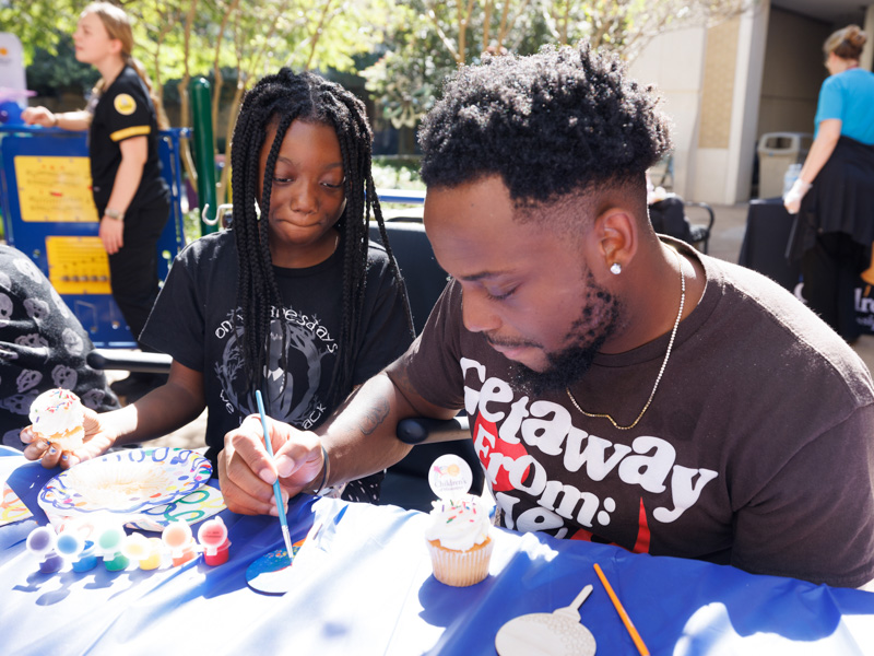 Children's of Mississippi patient Tamia McGee and her dad, Craig, of Yazoo City enjoy cupcakes and painting in the Rainbow Garden.