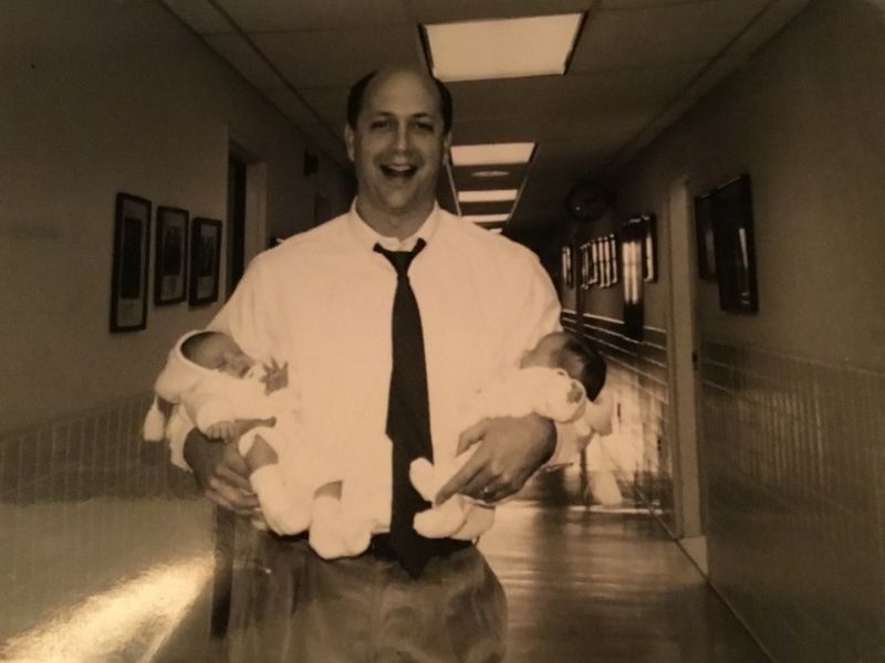 Cowan, founding director of the UMMC IVF program, beams while holding newborn twins Mary and Susan Lawrence.