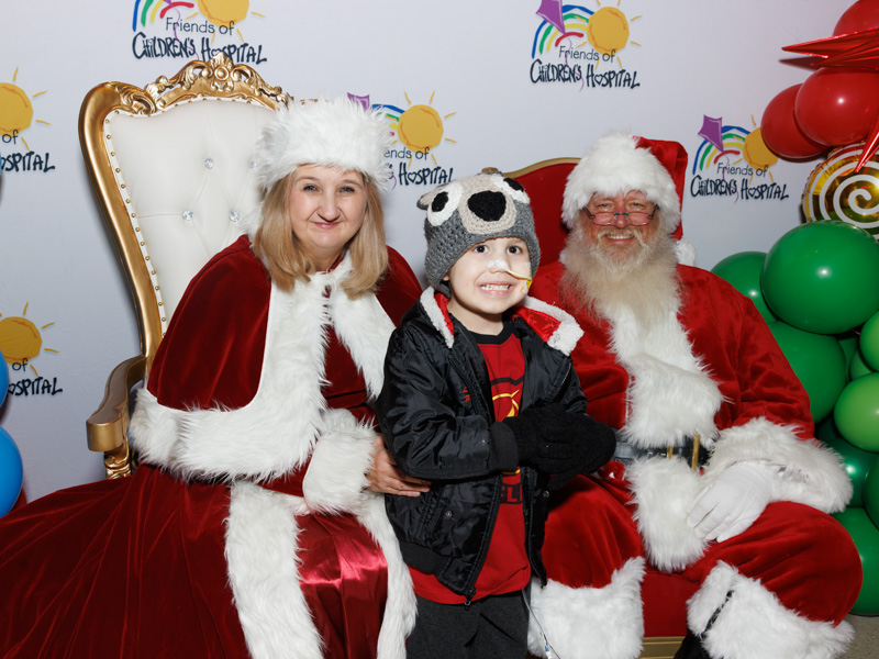 Children's of Mississippi patient Jaxon Shepherd of Columbia smiles with Santa and Mrs. Claus during BankPlus Presents Light-A-Light, an annual Friends of Children's Hospital celebration that started in 1989. Jay Ferchaud/ UMMC Communications