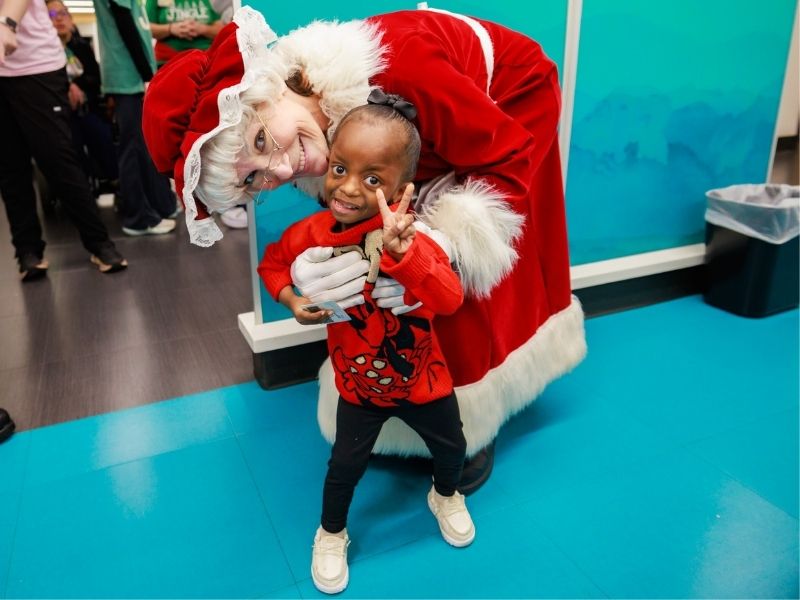 Children's of Mississippi patient Adalynn Gray of Greenwood smiles with Mrs. Claus.