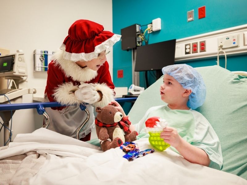 Mrs. Claus listens to a holiday story from Children's of Mississippi patient Gavin Shoemake of Richland.