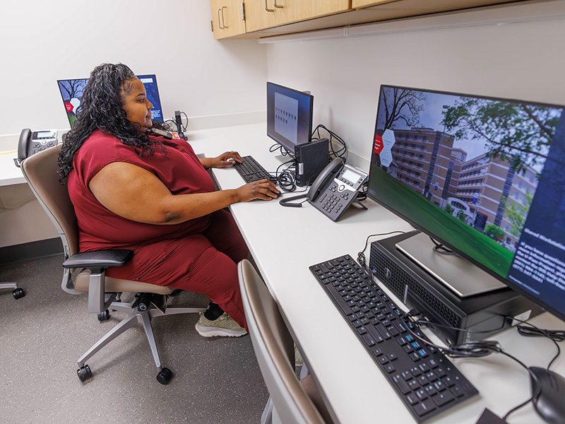 Registered Nurse Shanta Menton logs into a computer at the nursing station on the sixth floor of the Critical Care Tower.