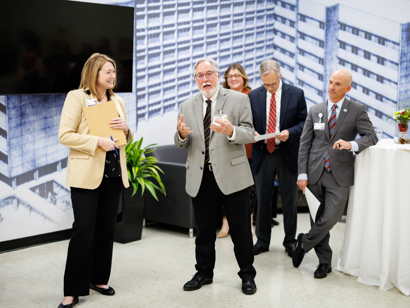 Dr. Ralph Didlake, center,, director of the UMMC Center for Bioethics and Medical Humanities, and Dr. Natalie Gaughf, assistant vice chancellor for academic affairs, greet members of the Academy for Excellence in Education during a museum preview held in December.