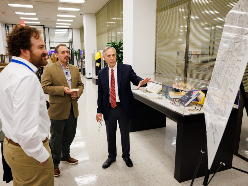 Dr. John Hall, right, describes a display from the collection of his mentor, Dr. Arthur Guyton, to, from left, Dr. Eric Vallender, associate professor of psychiatry, and Dr. Nathan Tullos, associate professor of advanced biomedical education, during a museum preview for members of the Academy for Excellence in Education in December.