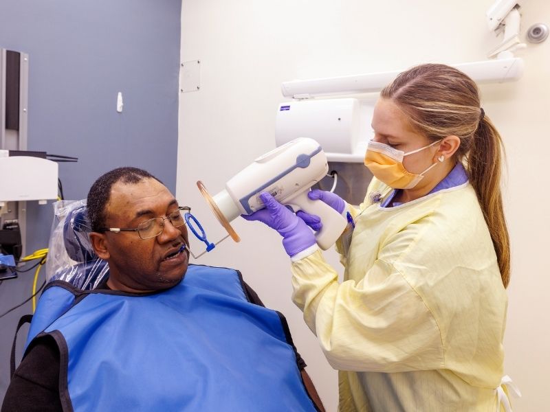 Dental Hygiene student Emily Barnes takes x-rays of Lorenzo Boyland's teeth during Dental Mission Week.