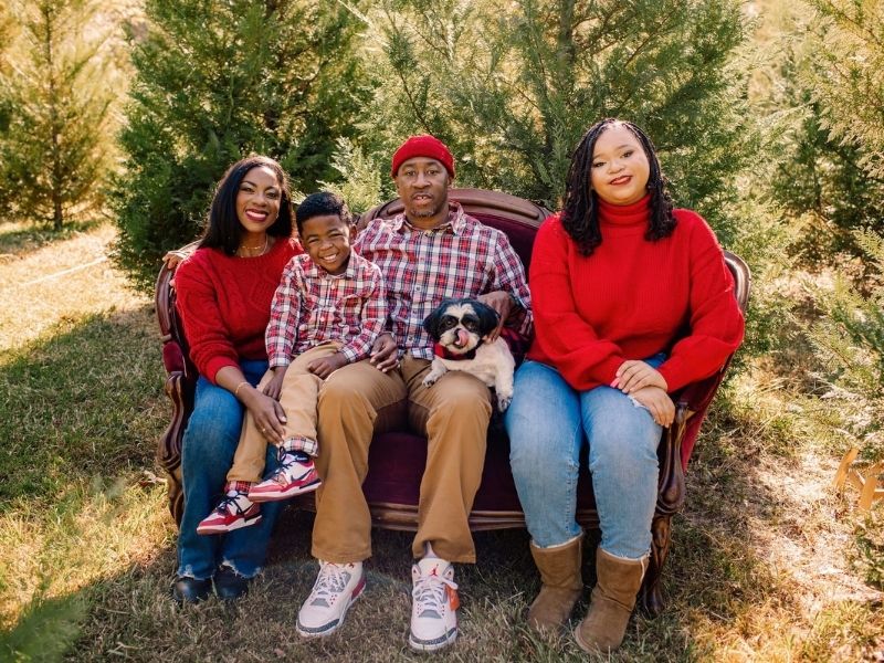 In this recent family photo, Bell and husband, Larry Catchings Jr., share a moment, and their taste in clothes, with Liam, 5, and Jai, 17, now a high school senior. With them, in Catchings' lap, is Oreo. (Photo courtesy of Dr. Keisha Bell)