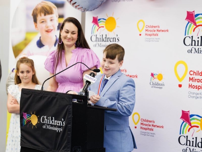 Mississippi's 2025 Children’s Miracle Network Hospitals Champion JD Johnson speaks during a news conference Friday as mother April Johnson and sister Bella look on.